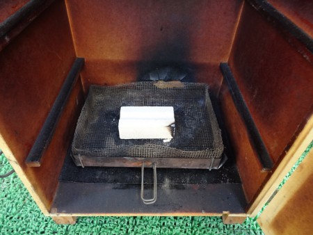 put the burnt wood on a grill not to burn the box.